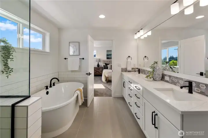Primary Bathroom  This primary bathroom pairs clean architectural lines with a spa-inspired layout. A freestanding soaking tub sits beneath natural light, while a tiled walk-in shower with glass enclosure and built-in niche offers streamlined functionality. The dual-sink vanity with quartz countertops and matte black fixtures provides generous storage and refined contrast.    Set within Bothell’s Canyon Park neighborhood, this en suite reflects the detail and finish quality expected in luxury new construction homes. The well-planned design supports both daily routine and retreat within a contemporary residence located in the Northshore School District.    These photos are from a past Robinson Plan at a different community, so overall plan, colors, building orientation, finishes, home outlook, and other details can and WILL vary. All photos, renderings, site maps, and floorplans are for visualization purposes only.