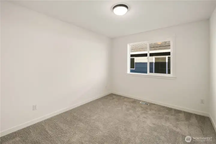 Secondary Bedroom Two  Designed with efficiency in mind, this upper level bedroom offers a well-proportioned layout that maximizes usable space. Recessed lighting and neutral tones create a clean, cohesive feel, while soft carpeting enhances everyday comfort. The streamlined footprint supports flexible use without wasted square footage.    Situated in Bothell near Canyon Park conveniences, this secondary bedroom reflects the quality associated with high-end contemporary new construction located within the Northshore School District.    These photos are from a past Robinson Plan at a different community, so overall plan, colors, building orientation, finishes, home outlook, and other details can and WILL vary. All photos, renderings, site maps, and floorplans are for visualization purposes only.