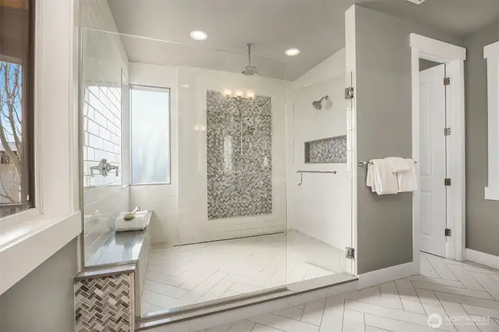 Jaw-dropping walk-in shower with dual heads and frosted privacy windows in the primary en-suite bath.