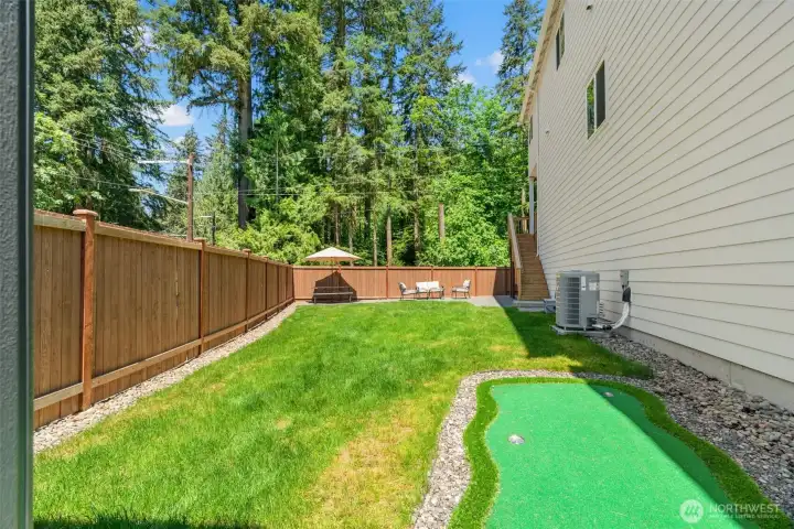 Fenced backyard with putting green.
