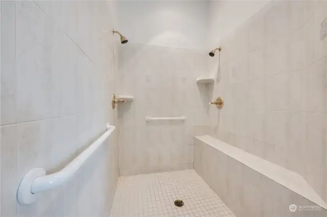 Spacious tile shower with double shower heads in master bath.