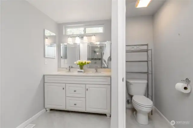 Custom vanity with dual sinks and toilet room