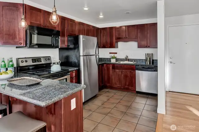Open kitchen with updated cupboards, granite counters and stainless appliances