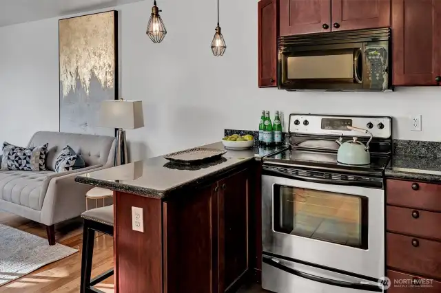 An eat-in kitchen with granite bar opens to the living room