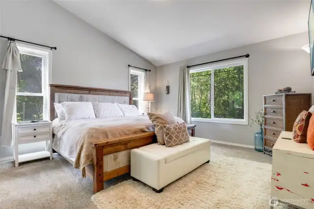 Upstairs, primary suite with vaulted ceilings.