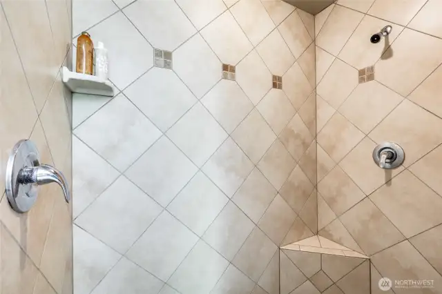 Walk-in shower in primary suite.