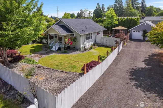 View of the fully fenced yard and driveway with garage.