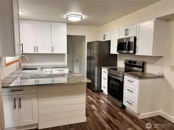 Updated kitchen with new cabinets, countertops, plumbing and appliances.