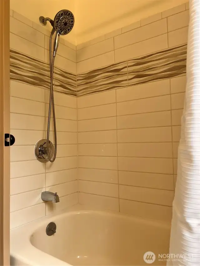Main floor bath tub/shower with tile surround