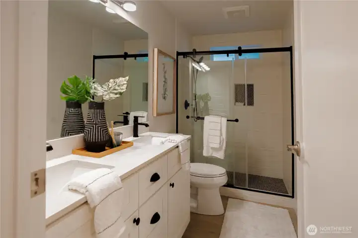 Remodeled bathroom with tiled shower, flooring and updated vanity and fixtures.