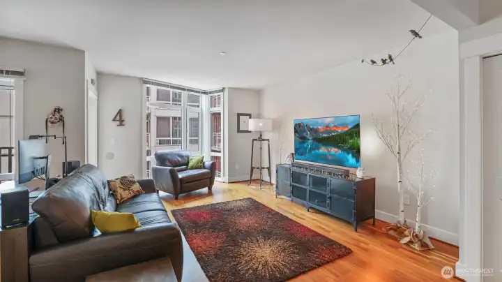 Living room with floor to ceiling windows, refinished walnut floors.