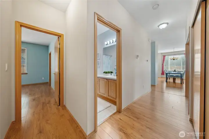 View from end of hall looking towards full bathroom and a peek at the primary bedroom with en-suite.