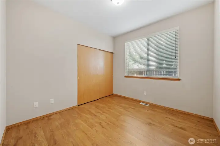 Bedroom 2 with wall-to-wall closet.  Window looks out to the side yard.