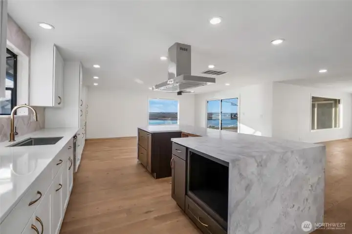 This elegant kitchen is beautiful and functional, with an under-counter space for your microwave or cookbooks to display, a chef's hood/venting system, and a large open sink with a view out to the lake with the garden window, perfect for plants and natural light.