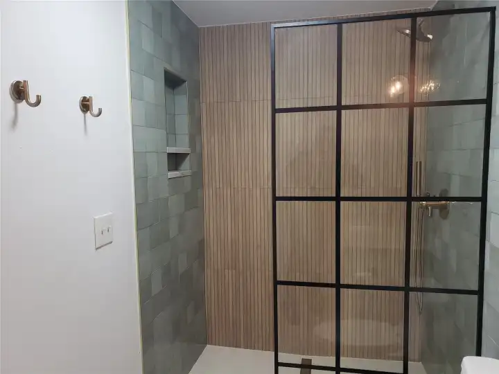 Another view of the 3/4 bath near the living room, with its exquisite tile and bamboo-look shower!