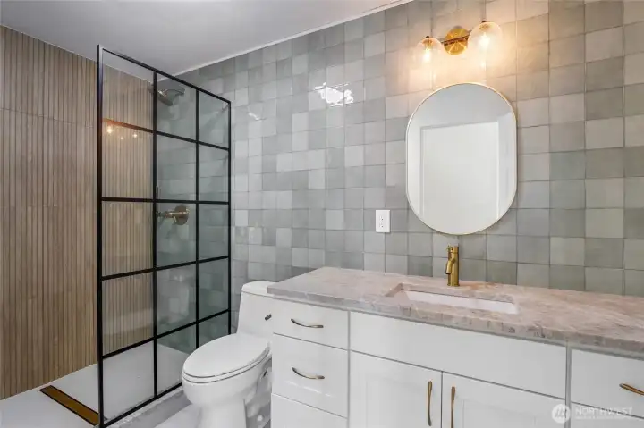 Did you say WOW!? And this is just the first of three upper end bathrooms! Once purely functional, this bathroom has been transformed with high-end finishes, a statement shower, and refined lighting and tile that elevate the entire space.