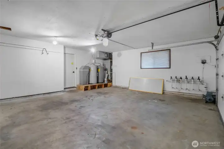 This large two-car garage is where you'll find the water softener, hot water tank, furnace and an array of water sprinkler valves (sprinkler system not currently in service).