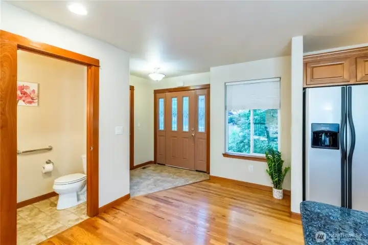 Convenient main-floor entry with nearby powder room creates a functional layout for guests and everyday living. Hardwood floors and large windows bring warmth and natural light to the space.