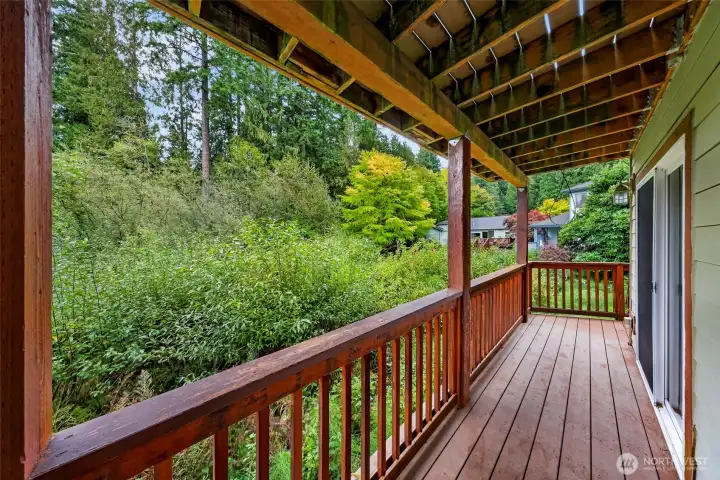 Private back deck provides a comfortable outdoor retreat with views of surrounding trees and natural green space just beyond the yard.