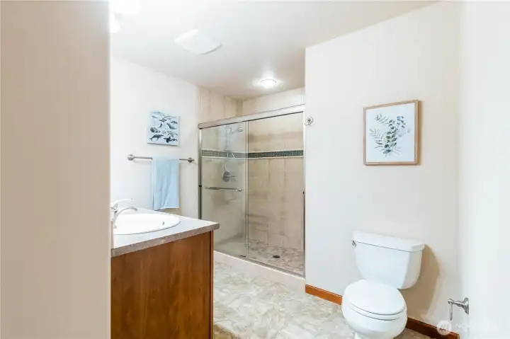 Primary bathroom with walk-in shower featuring tile surround and glass enclosure.
