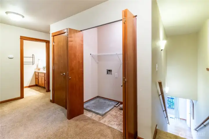 Laundry area conveniently located upstairs with bi-fold doors, positioned near the bedrooms for everyday practicality.