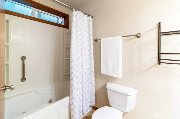 Main full bathroom with tub/shower combination and window for natural light.