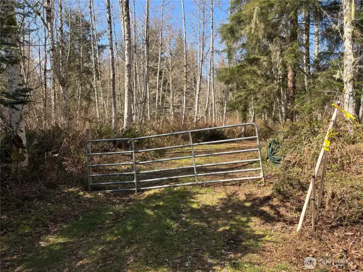 Gated entry to property. Survey marker for property to right to the gate.