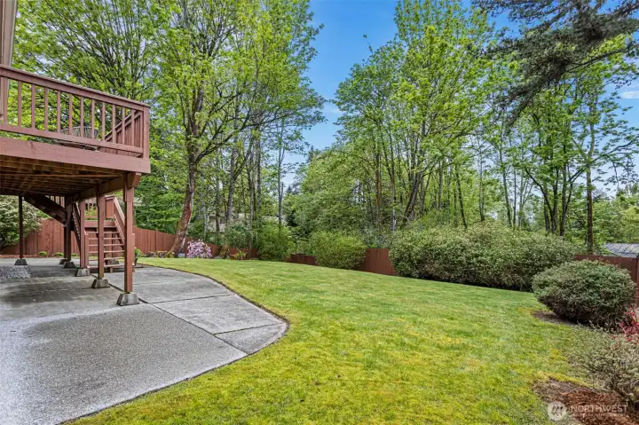 Peaceful backyard with patio, lawn and garden beds.