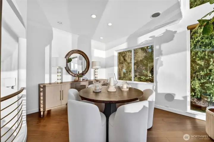 Sun-drenched and open, the main level dining room flows naturally from the living room. A bright, welcoming space where the trees and lake beyond the windows set the scene for every meal.