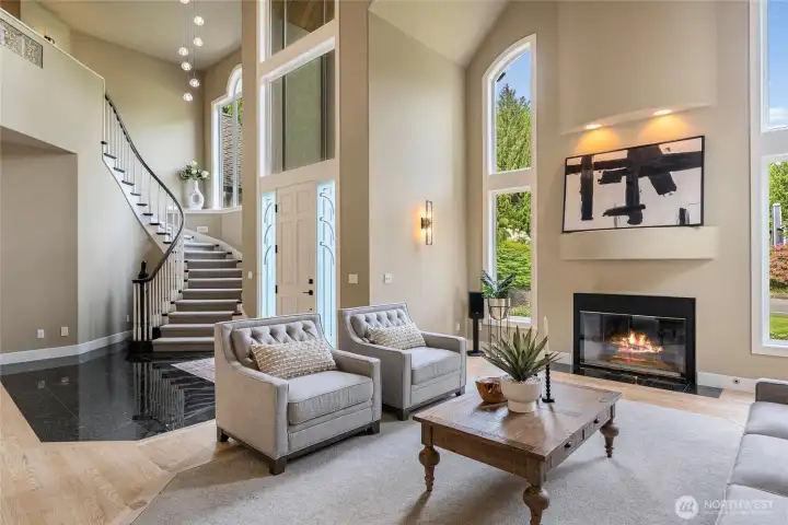 Grand foyer with curved staircase and stunning modern light fixtures setting the perfect ambiance