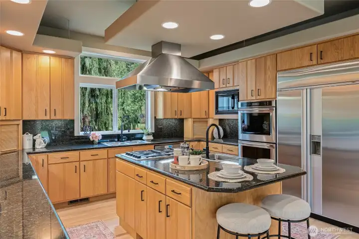 Large chefs kitchen with double ovens, sub-zero refrigerator, 2 working spaces with sinks, and gas/electric cook top.