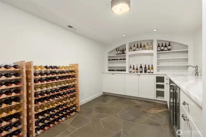 Impressive wine cellar featuring custom storage and a stone floor. Impressive wine cellar featuring custom storage and a stone floor.