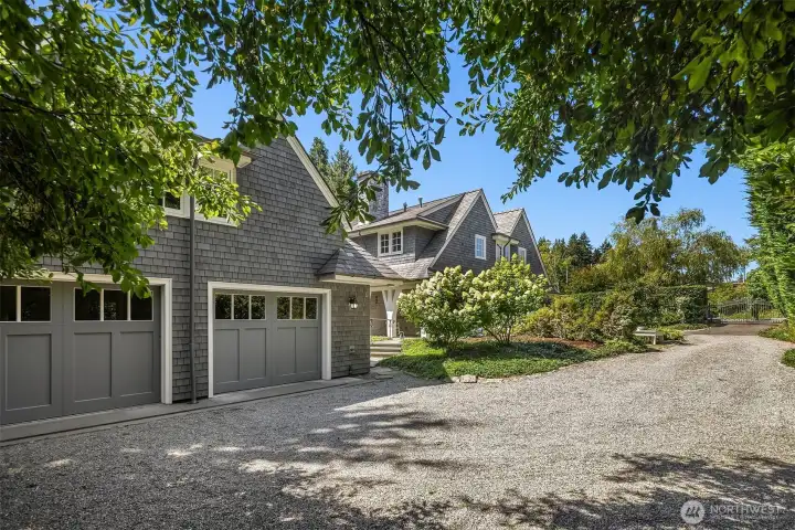 Charming exterior with a gravel drive and lush greenery. Charming exterior with a gravel drive and lush greenery.