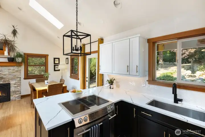 Beautifully remodeled kitchen with marbled quartz countertops and tile backsplash.