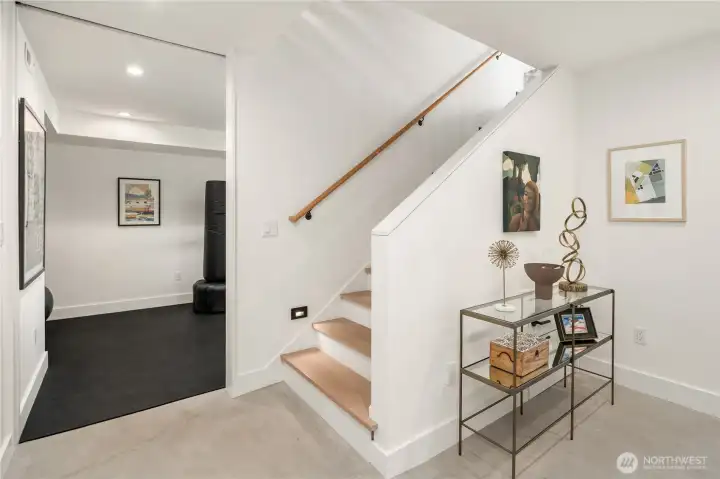 Stairs to lower level and access to workout room with rubber flooring. Stairs to lower level and access to workout room with rubber flooring.
