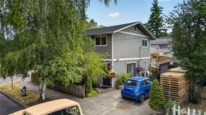 Duplex exterior with mature landscaping and off-street parking