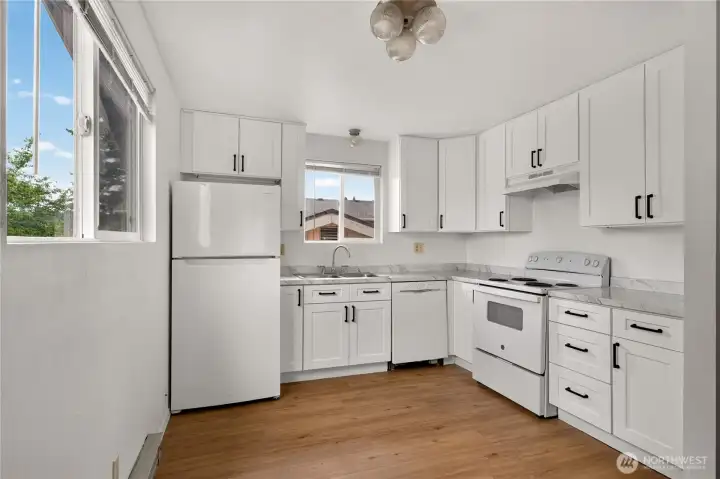 Unit B updated kitchen with white shaker cabinets and new flooring
