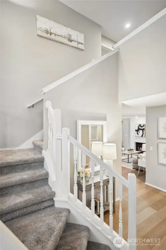 A spindled staircase off the entry leads to the upper level bedrooms and baths.