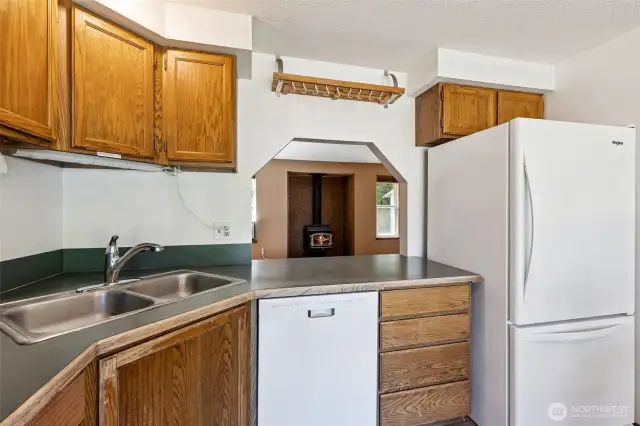 Newer appliances in the kitchen all stay with the home! Notice the clever pass-thru window to the living room.