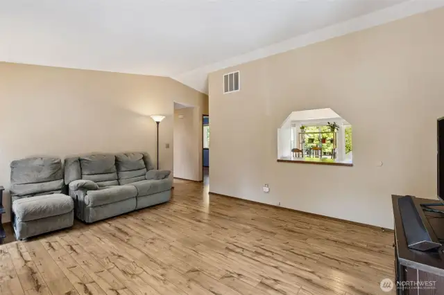 Spacious living room with nice laminate flooring and vaulted ceiling.