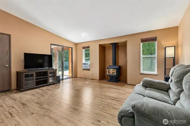 Living room has a wood stove. Door on the left leads to the 2 car garage. Slider door leads out to the bonus space.