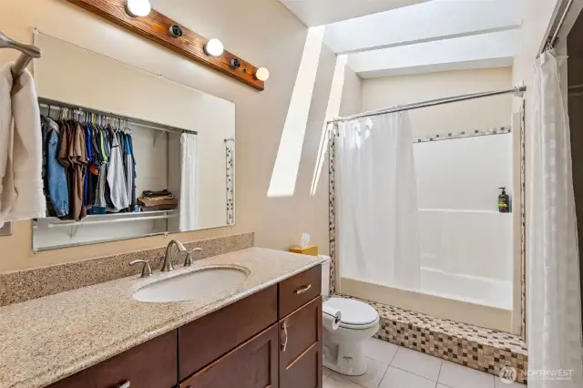 Primary en suite bathroom with closet, shower/tub combo and skylights for lots of lighting!
