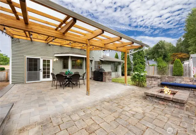 Sitting on a flat fenced lot with covered patio and fire pit