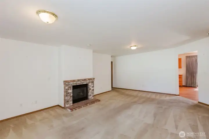 Large living room with gas fireplace with brick hearth
