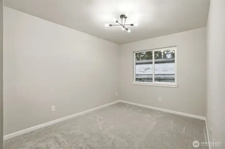 Second bedroom featuring large window and bright, open feel