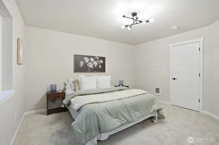 Comfortable primary bedroom featuring plush carpet and bright, airy feel