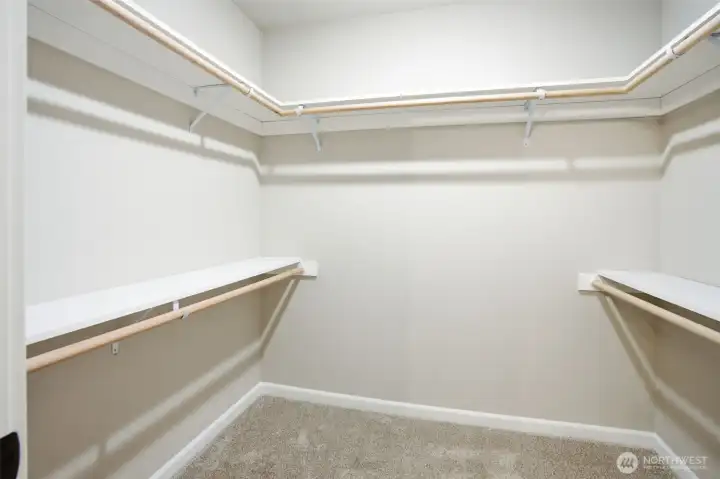 Primary walk-in closet offering generous storage and organization