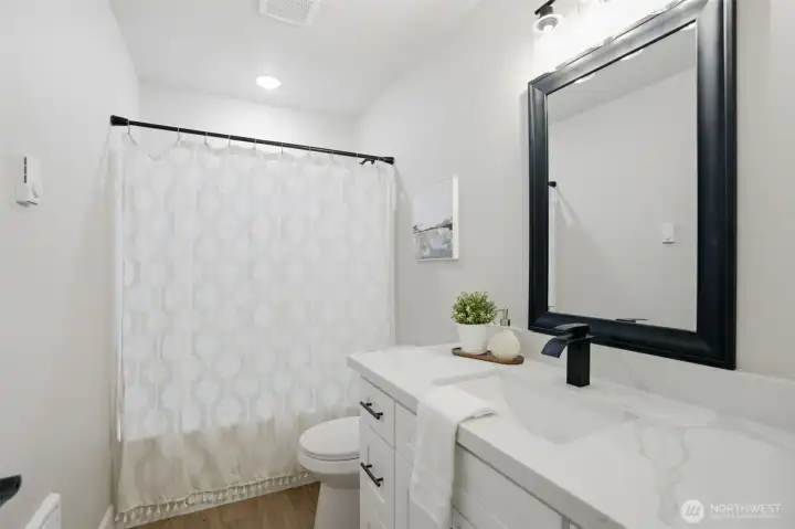 Hallway bathroom with functional layout and gorgeous quartz countertops