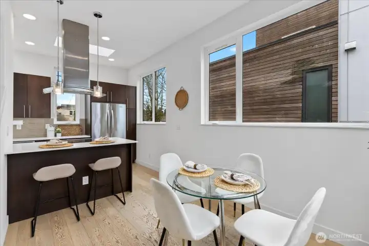 Big windows, light floors and modern finishes found in the gorgeous dining/kitchen space.