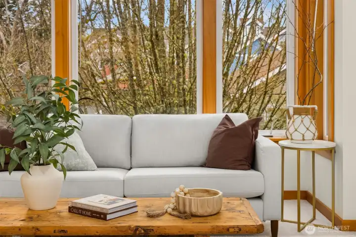 The living room looks out to the trees lining Winslow Way W.